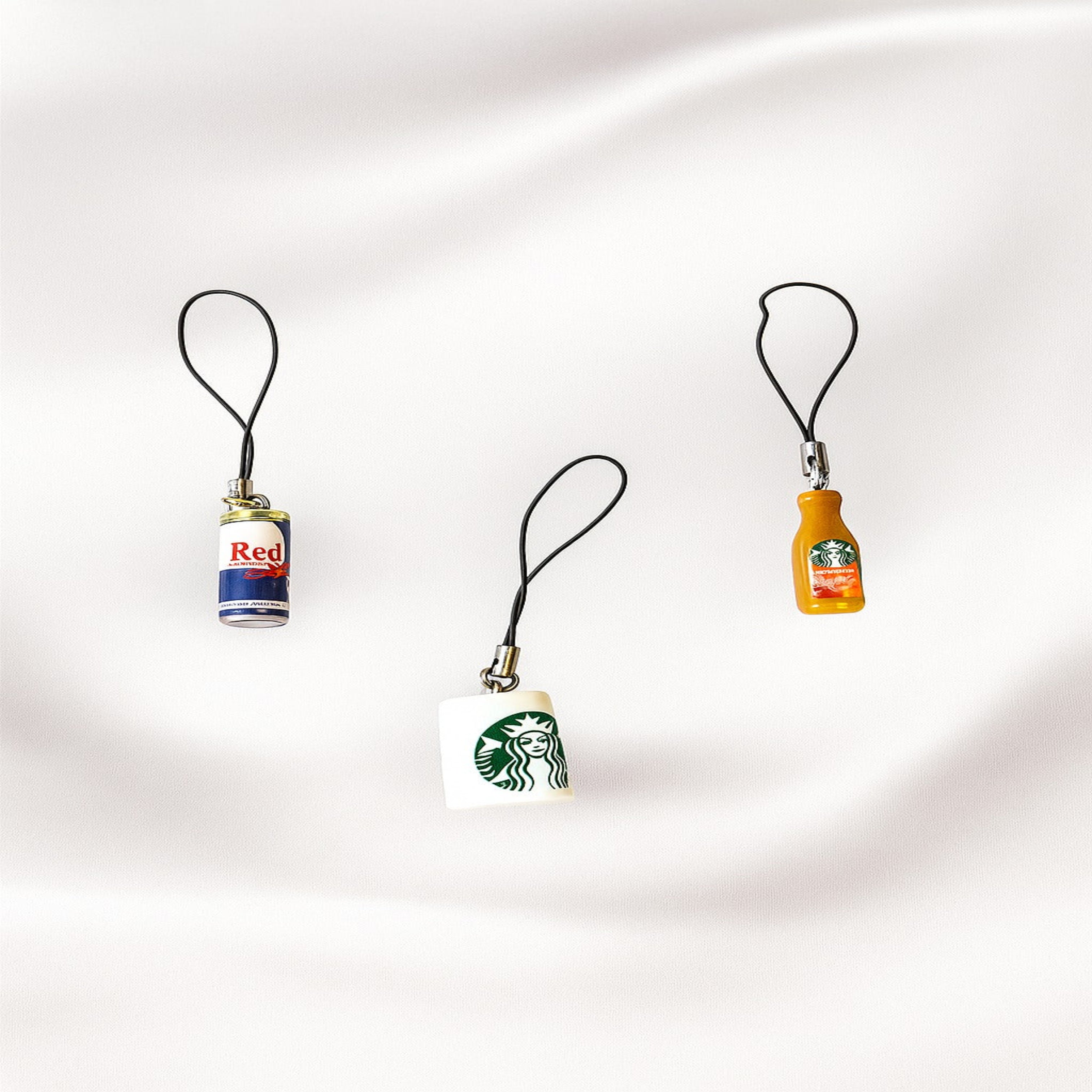 Three small bottle-shaped keychains on a white background