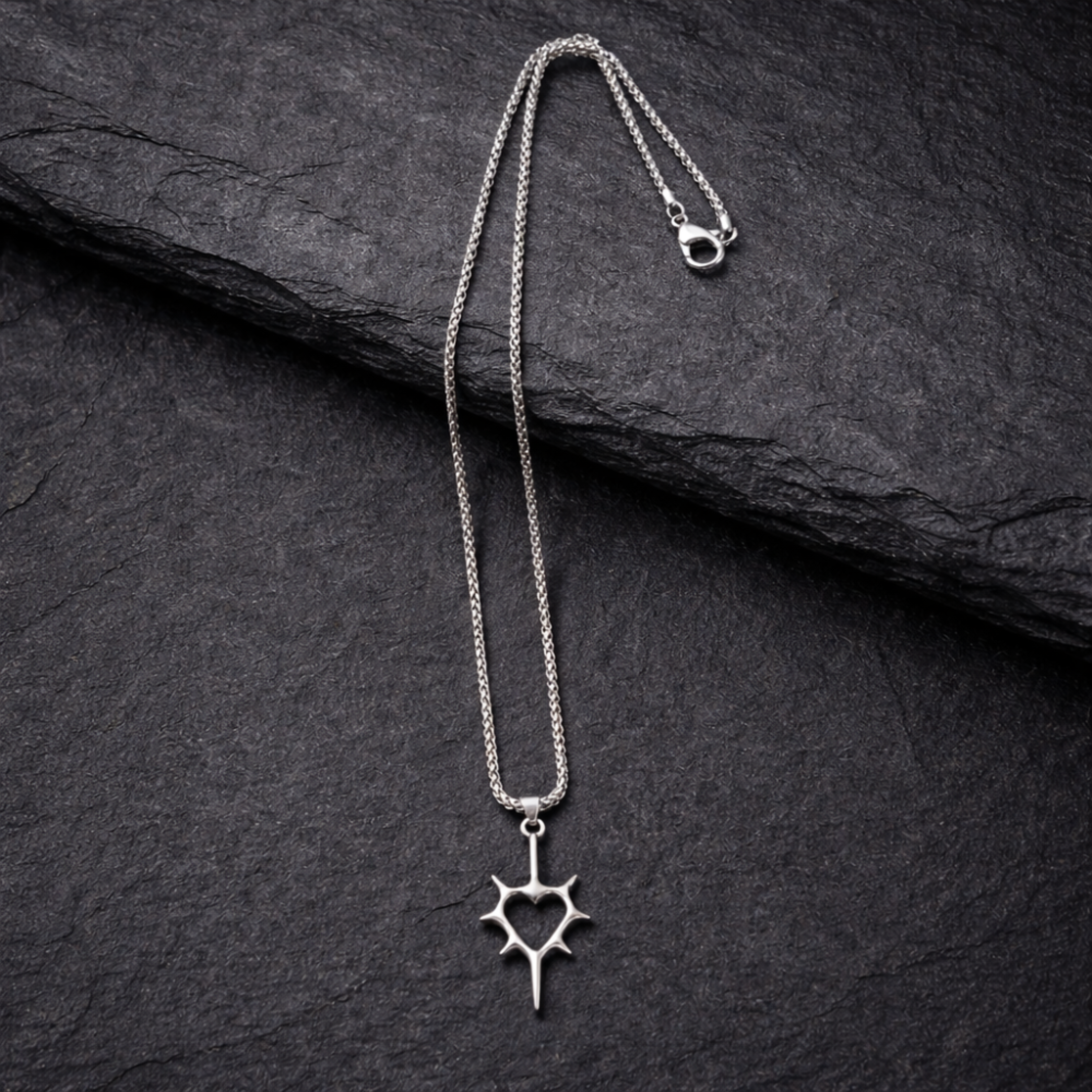 Silver necklace with a star-shaped pendant on a dark stone surface